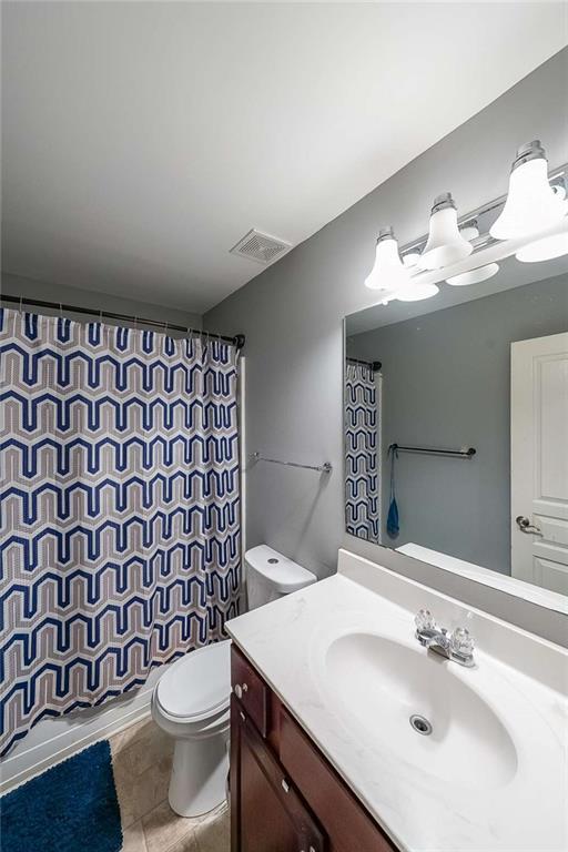7835 Keepsake Ln, Flowery Branch, GA 30542 - bathroom with vanity, toilet, curtained shower, and tile patterned flooring