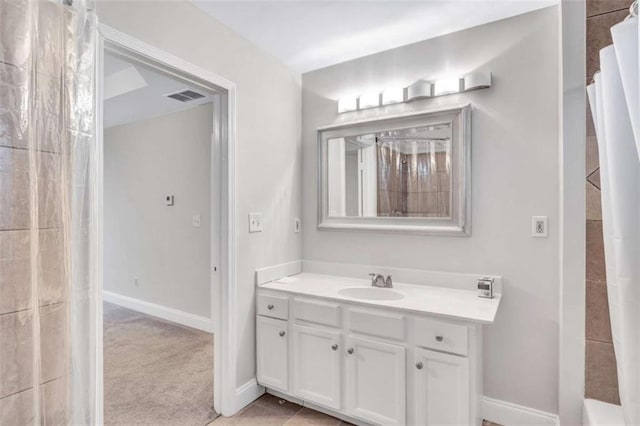 bathroom with walk in shower, vanity, and tile patterned floors