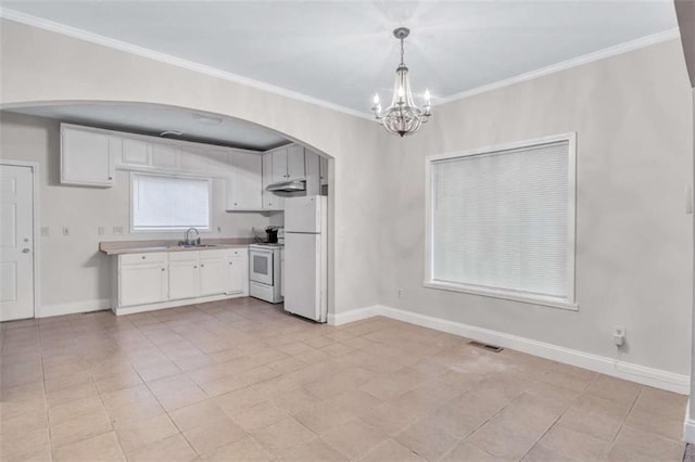 kitchen with sink, white appliances, white cabinetry, and pendant lighting