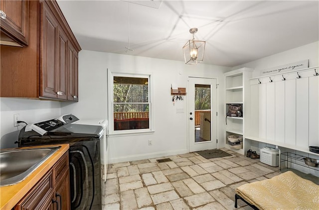 clothes washing area with sink, cabinets, and washing machine and dryer