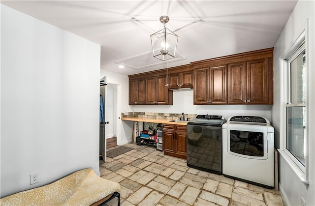 clothes washing area with sink, cabinets, and independent washer and dryer