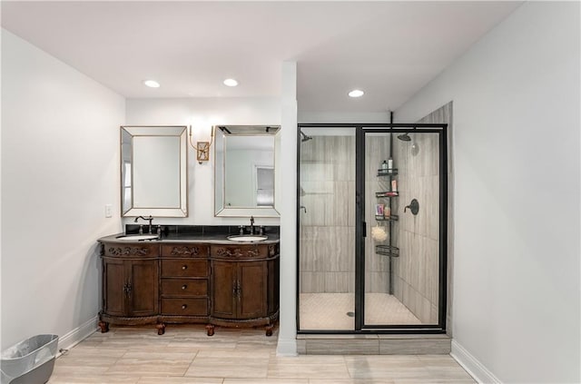 bathroom featuring a shower with shower door and vanity