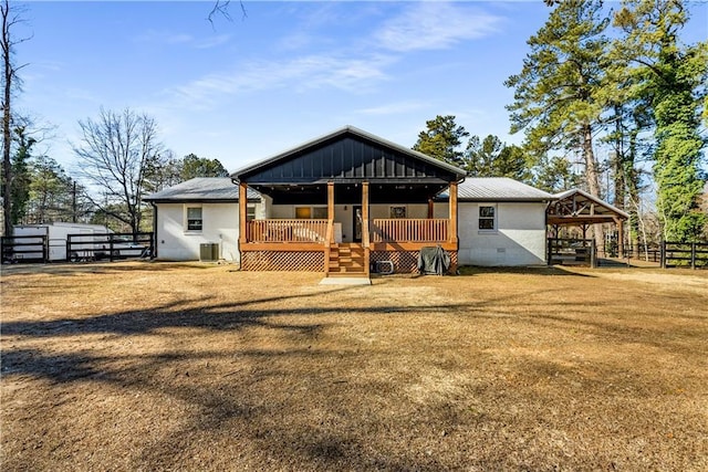 view of front of house with central AC unit and a front lawn