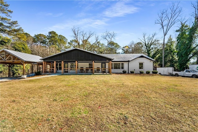 rear view of property featuring a porch and a lawn