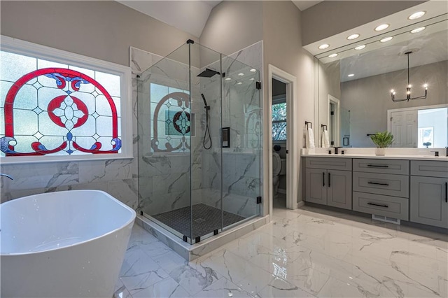 full bath with marble finish floor, a marble finish shower, a freestanding tub, and vanity