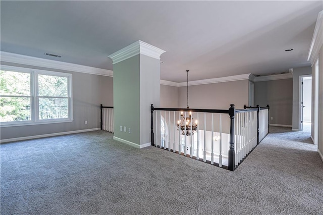 carpeted empty room featuring a chandelier, visible vents, crown molding, and baseboards