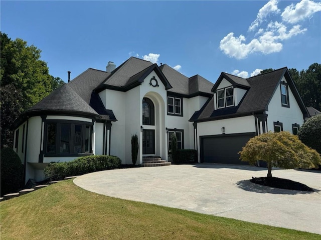 view of front facade with a garage, driveway, and stucco siding