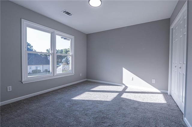 unfurnished bedroom with a closet, carpet flooring, visible vents, and baseboards