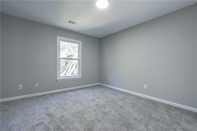 unfurnished room with carpet floors, baseboards, and visible vents