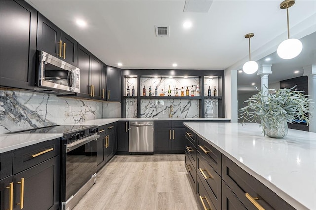 kitchen featuring open shelves, visible vents, appliances with stainless steel finishes, light wood-type flooring, and ornate columns