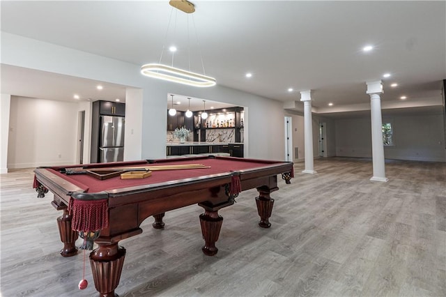 rec room with baseboards, light wood finished floors, recessed lighting, and ornate columns