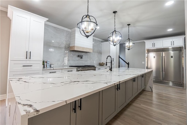 kitchen featuring white cabinetry, stainless steel built in fridge, decorative backsplash, and stove