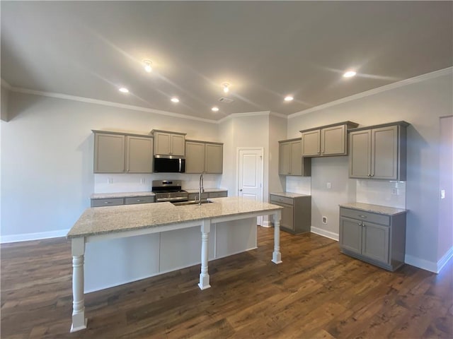 kitchen featuring gray cabinetry, a center island with sink, and appliances with stainless steel finishes