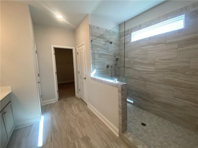 bathroom with vanity and a tile shower