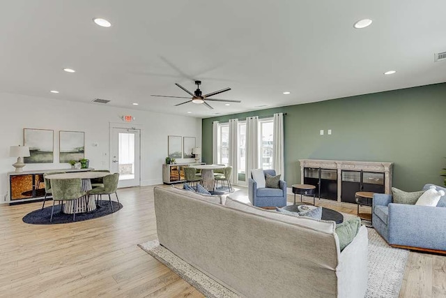 living room with ceiling fan and light wood-type flooring