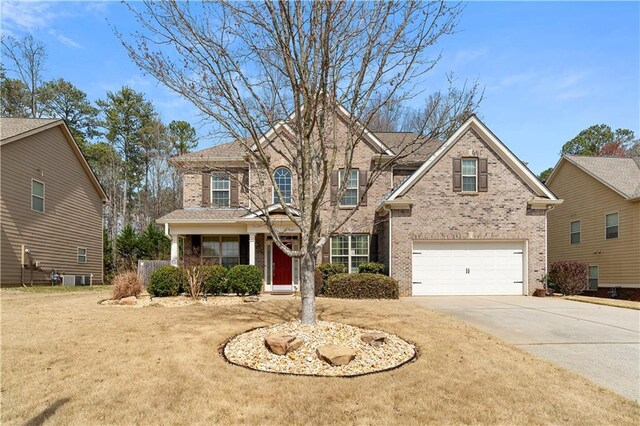 traditional home with brick siding, an attached garage, and concrete driveway