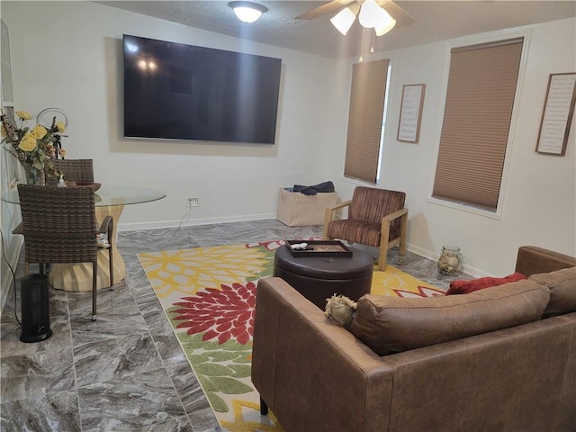 living room with ceiling fan and a textured ceiling