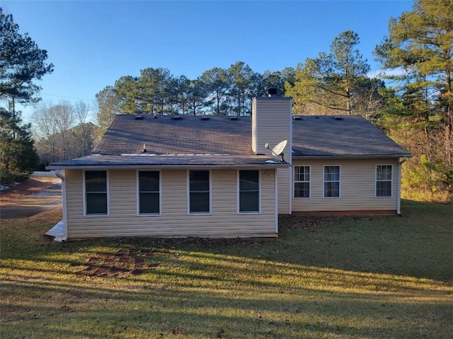 rear view of property featuring a lawn