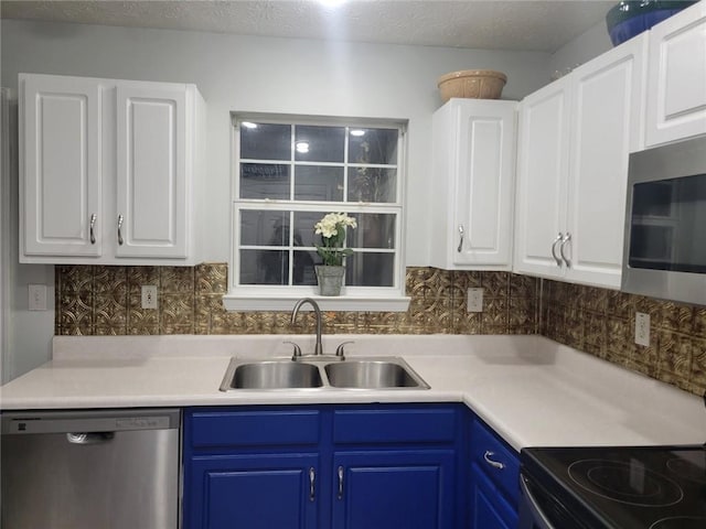 kitchen featuring tasteful backsplash, sink, white cabinets, stainless steel appliances, and blue cabinetry