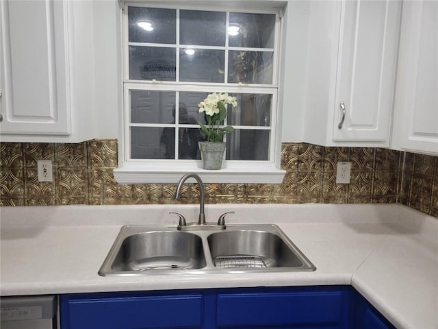 kitchen with blue cabinets, sink, white cabinets, and decorative backsplash