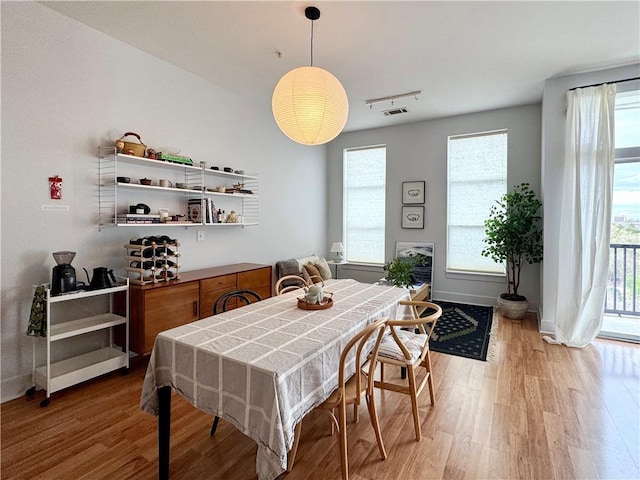 dining room with light wood-type flooring, baseboards, and visible vents