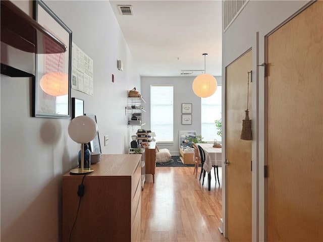 hallway with visible vents and light wood-type flooring