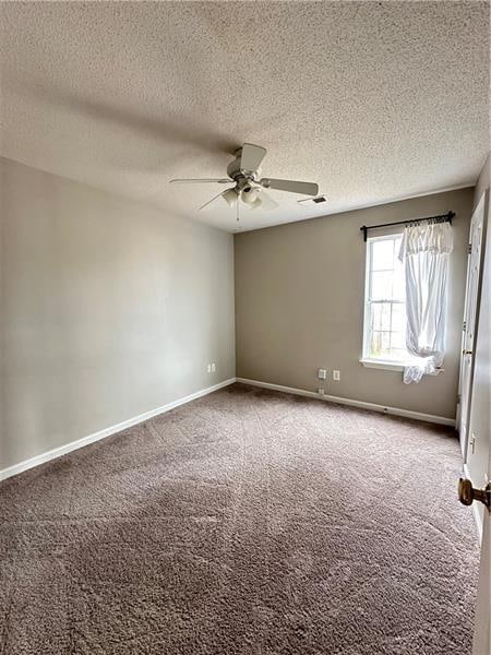 spare room with carpet floors, a textured ceiling, and ceiling fan