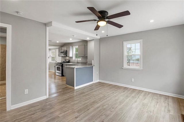 kitchen featuring light hardwood / wood-style floors, appliances with stainless steel finishes, plenty of natural light, and gray cabinets