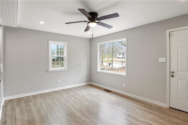 unfurnished room with light hardwood / wood-style floors, a healthy amount of sunlight, and ceiling fan