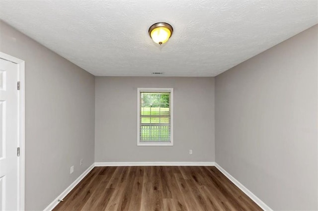 5514 E Stoneway Ct, Villa Rica, GA 30180 - unfurnished room with dark wood-type flooring, baseboards, and a textured ceiling