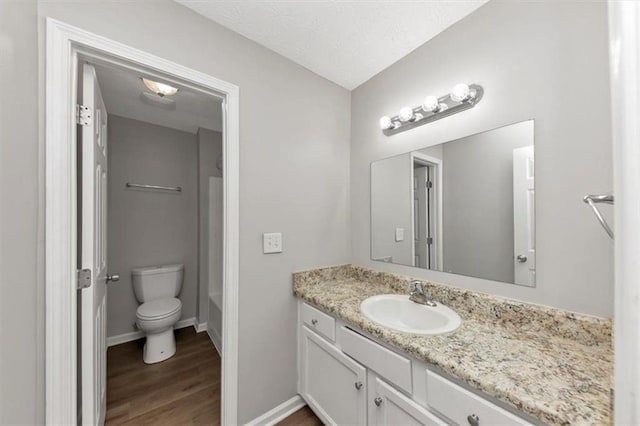 5514 E Stoneway Ct, Villa Rica, GA 30180 - bathroom featuring vanity, wood finished floors, toilet, baseboards, and tub / shower combination