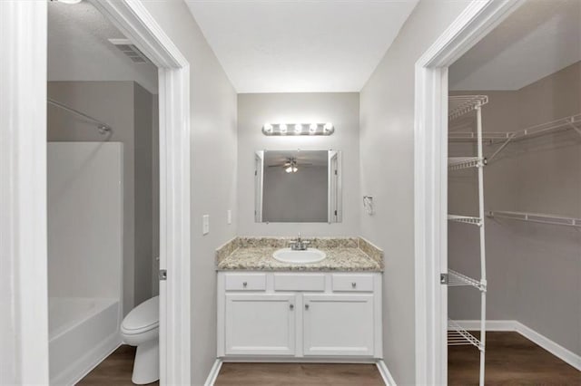 5514 E Stoneway Ct, Villa Rica, GA 30180 - bathroom with vanity, wood finished floors, toilet, baseboards, and tub / shower combination