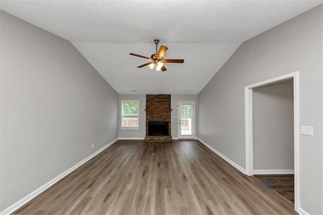 5514 E Stoneway Ct, Villa Rica, GA 30180 - unfurnished living room with ceiling fan, vaulted ceiling, wood finished floors, baseboards, and a fireplace