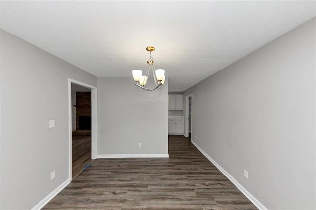 5514 E Stoneway Ct, Villa Rica, GA 30180 - unfurnished room with a chandelier, dark wood-style flooring, and baseboards