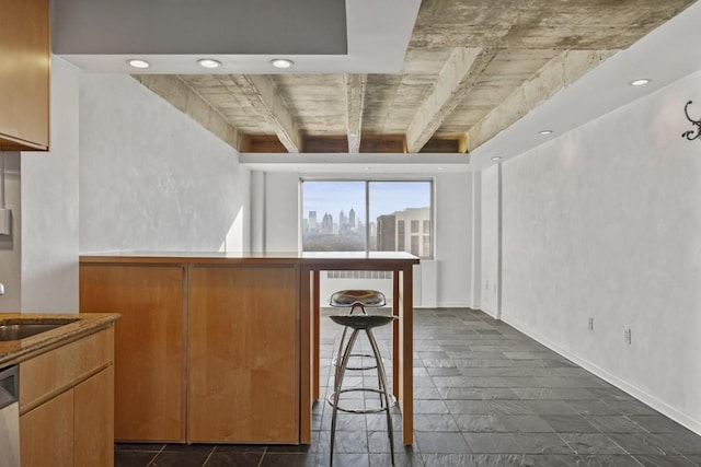 kitchen featuring sink, a kitchen breakfast bar, and dishwasher