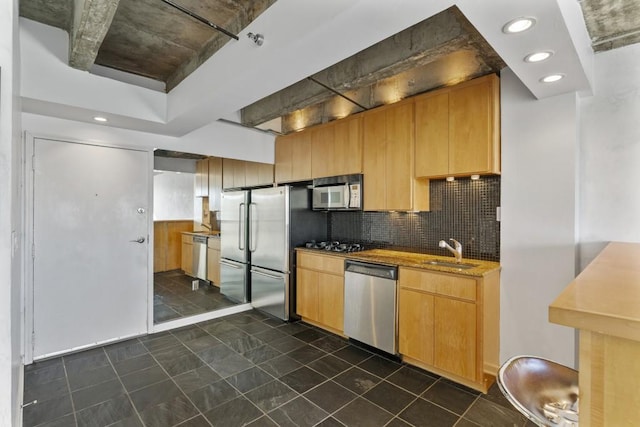 kitchen with sink, backsplash, and appliances with stainless steel finishes