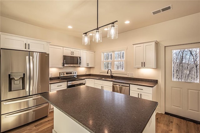 kitchen featuring plenty of natural light, visible vents, white cabinets, appliances with stainless steel finishes, and a sink