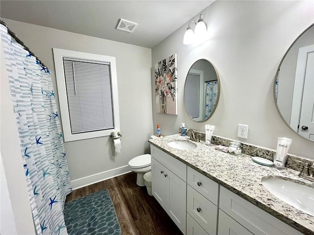 bathroom with vanity, toilet, wood-type flooring, and walk in shower