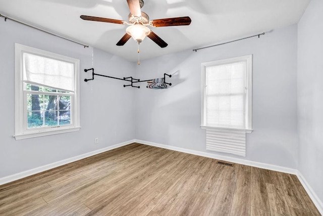 empty room with ceiling fan and light hardwood / wood-style flooring