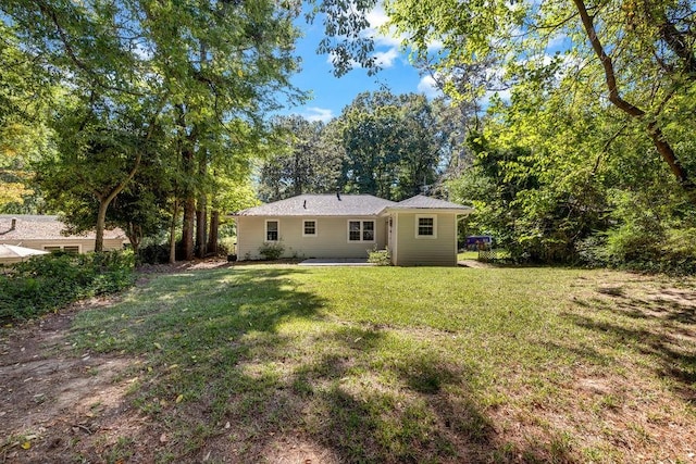 rear view of property with a yard