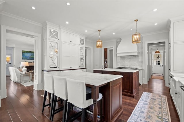 6440 Westchester Pl, Cumming, GA 30040 - kitchen featuring a center island, custom exhaust hood, dark wood-style flooring, recessed lighting, and white cabinetry