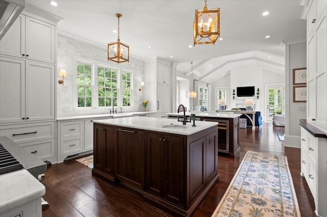 6440 Westchester Pl, Cumming, GA 30040 - kitchen featuring a chandelier, a sink, dark wood finished floors, a center island with sink, and white cabinets