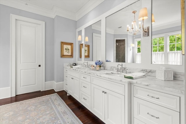 6440 Westchester Pl, Cumming, GA 30040 - bathroom featuring double vanity, a chandelier, crown molding, and wood finished floors