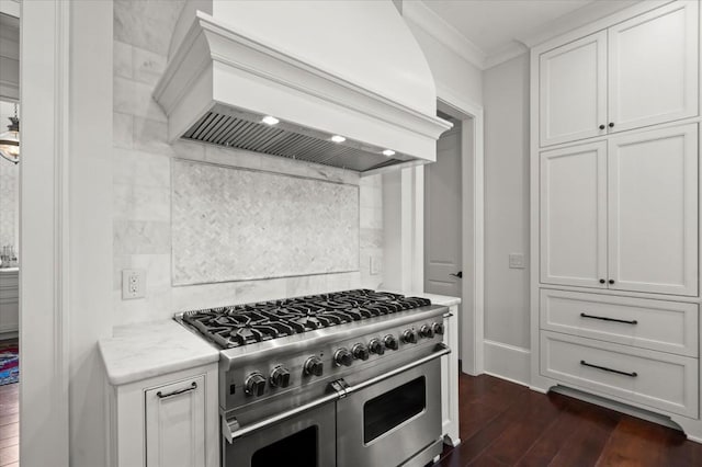 6440 Westchester Pl, Cumming, GA 30040 - kitchen with custom exhaust hood, range with two ovens, ornamental molding, dark wood-type flooring, and white cabinetry