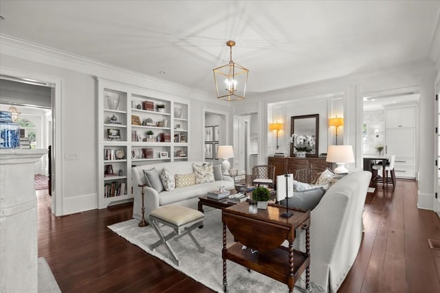 6440 Westchester Pl, Cumming, GA 30040 - living room featuring dark wood-type flooring, built in features, a chandelier, ornamental molding, and baseboards