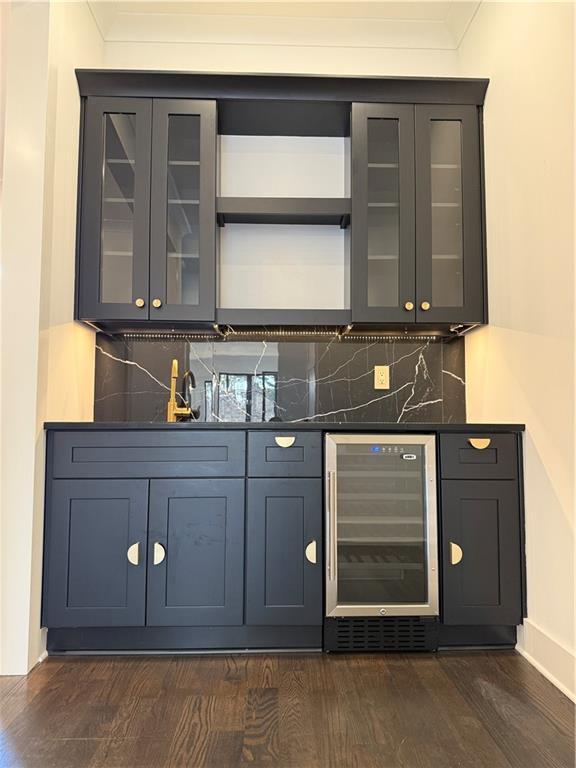 bar featuring tasteful backsplash, crown molding, dark hardwood / wood-style floors, and beverage cooler