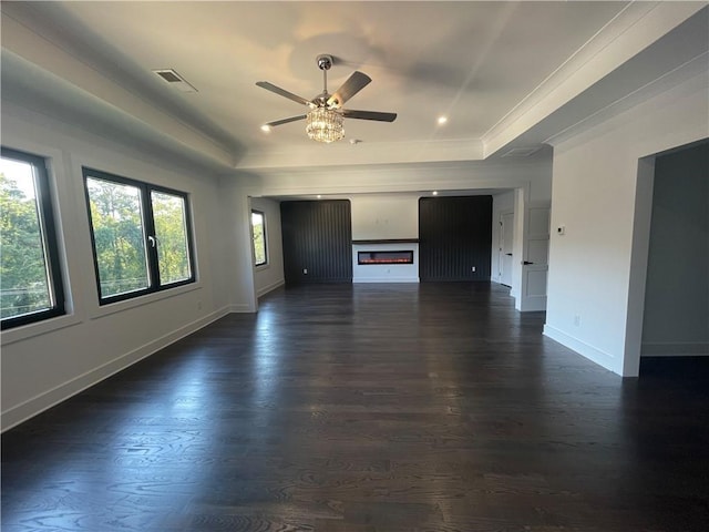 unfurnished living room featuring dark hardwood / wood-style flooring, a raised ceiling, and ceiling fan