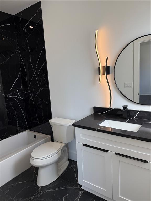 full bathroom with vanity, tiled shower / bath combo, and toilet