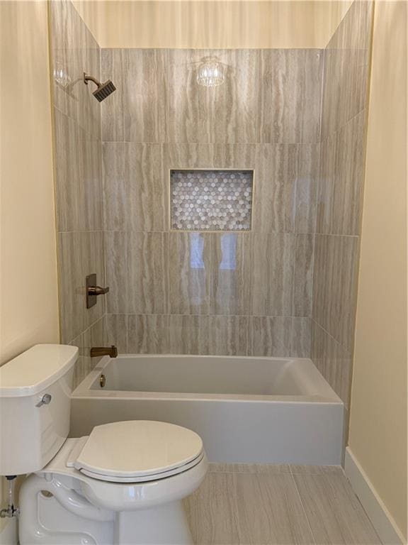 bathroom featuring tiled shower / bath and toilet