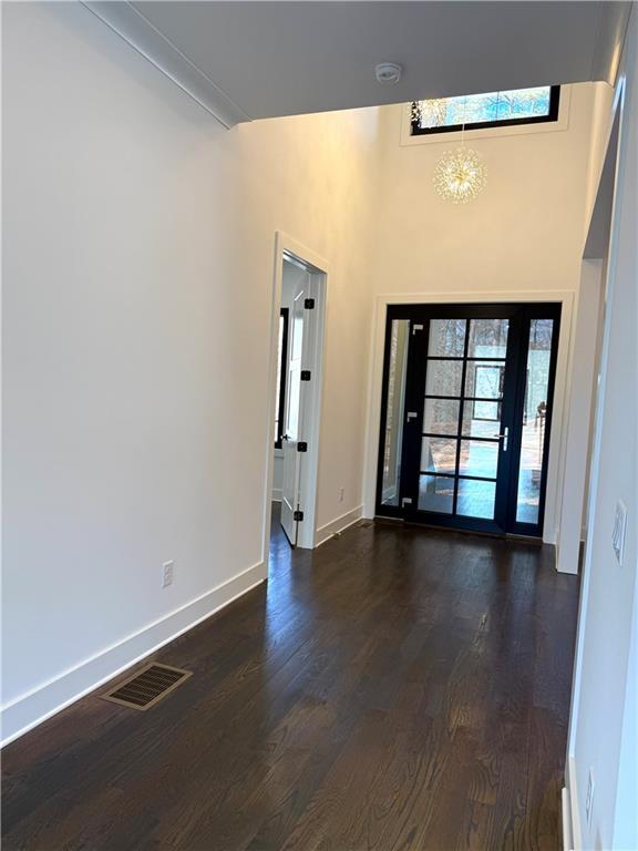 foyer entrance featuring dark wood-type flooring and a notable chandelier